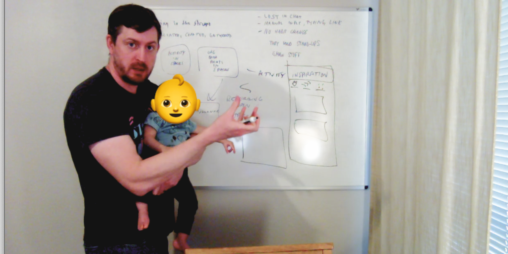 Peak WFH moment: Designer Terry at the Whiteboard, holding a baby
