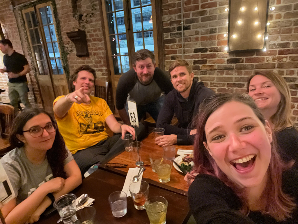 The leadership team sitting around a table. They’re smiling and having a good time.