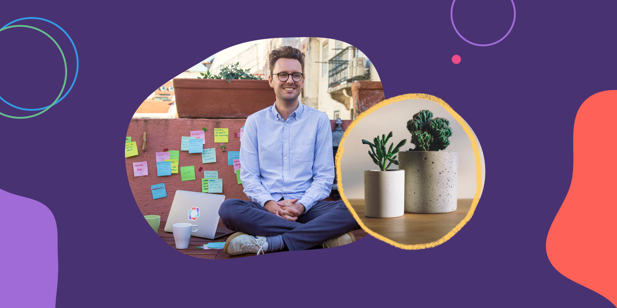 A man sits cross legged next to a wall covered in post-it notes with a plant nearby