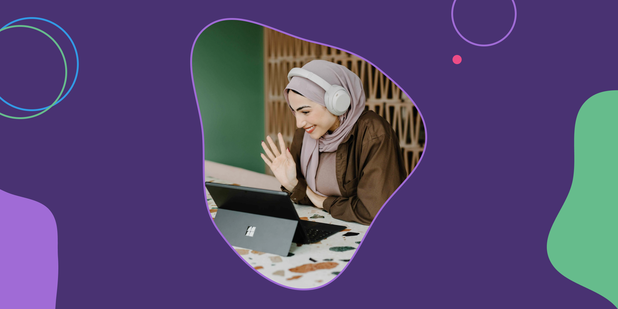 a woman waves into the laptop, attending an online meeting