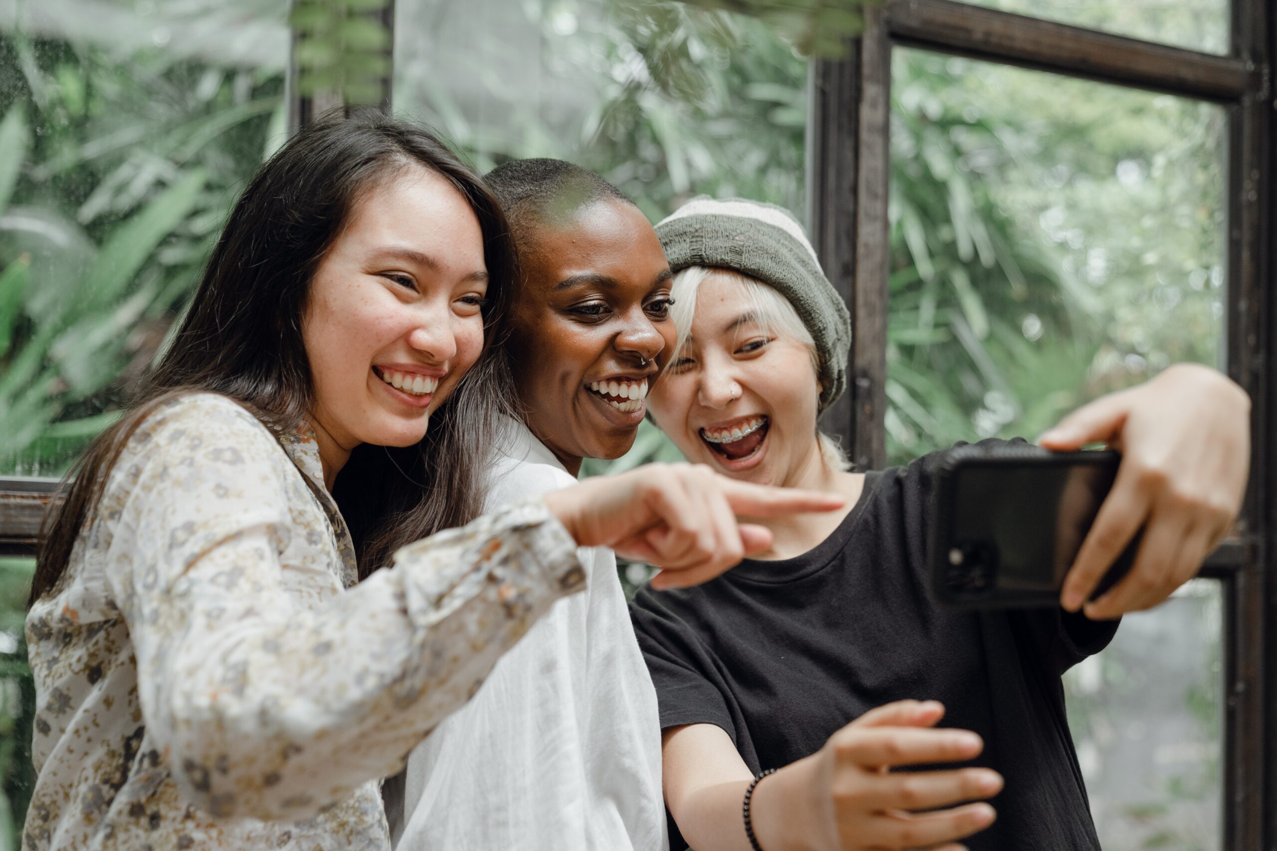 pexels-ketut-subiyanto-4350311 Image Description: Three laughing women looking at a mobile phone.