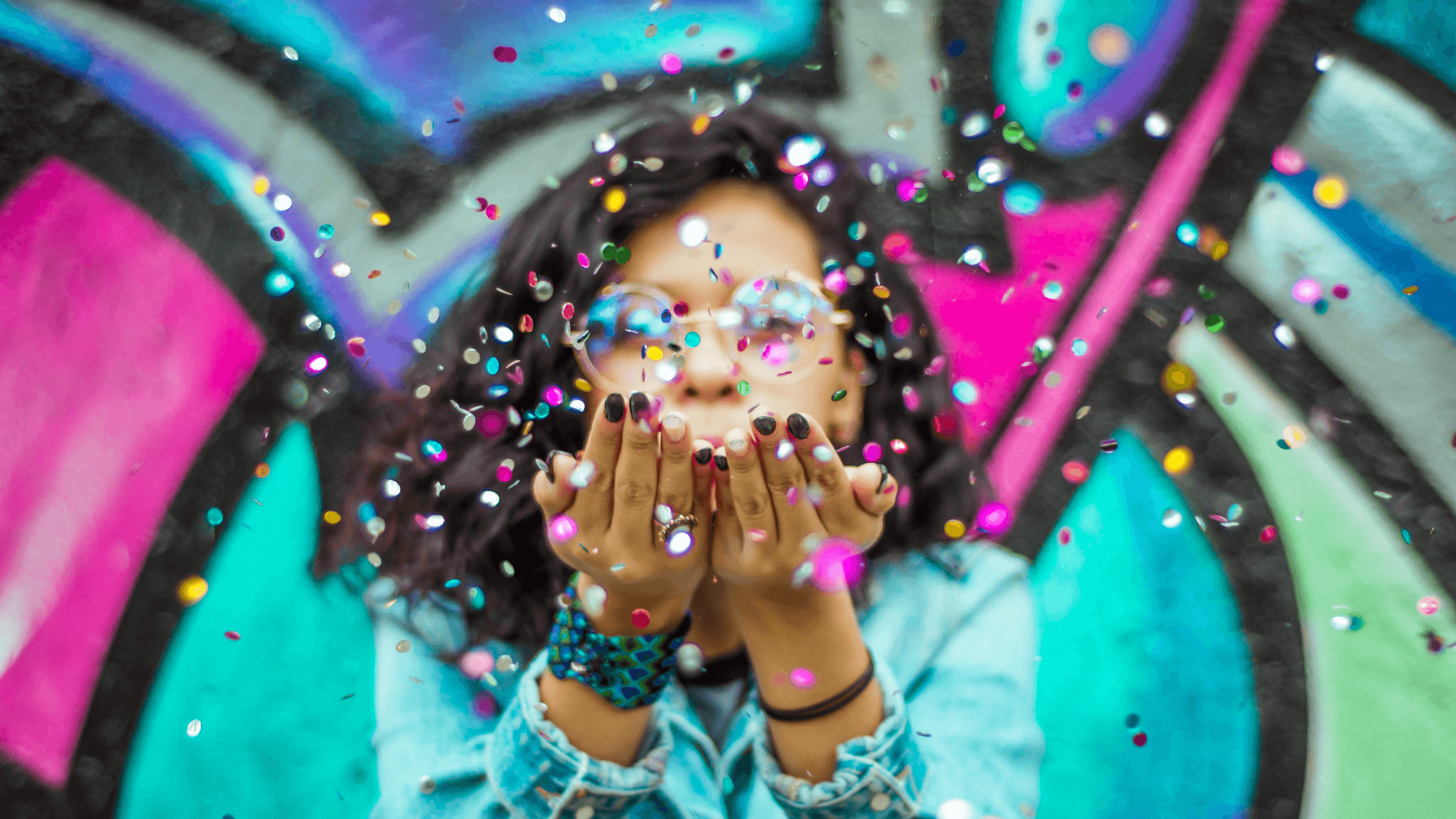 Image of woman blowing confetti in the air