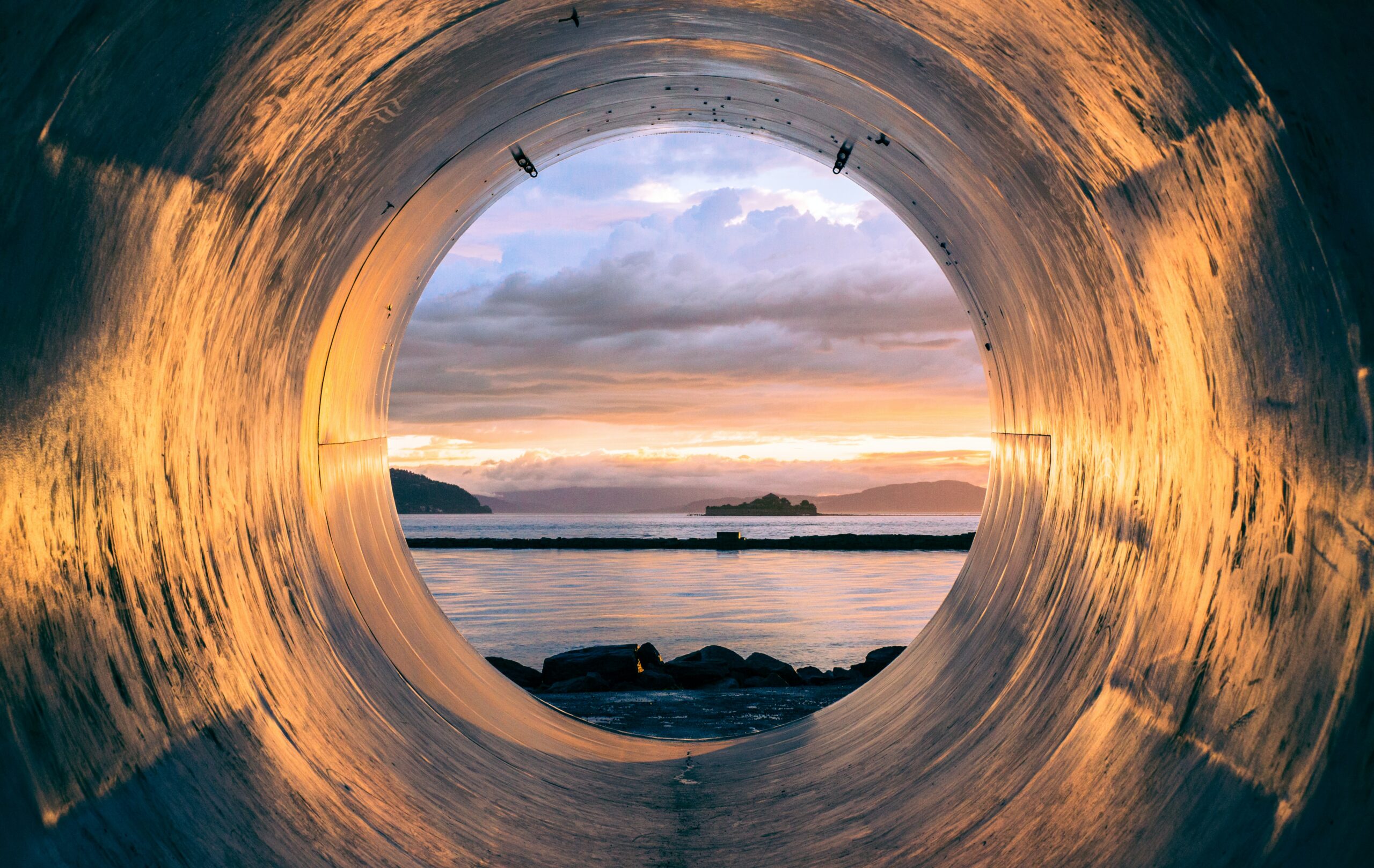 A tunnel leading to a sunset on the ocean