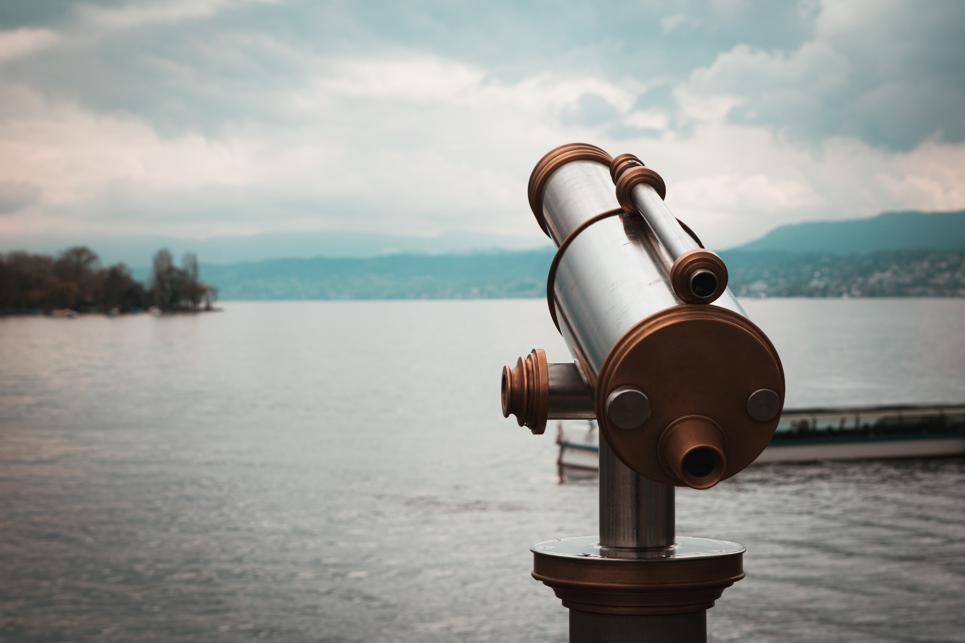 a telescope sitting on the shore of a lake pointed toward the sky