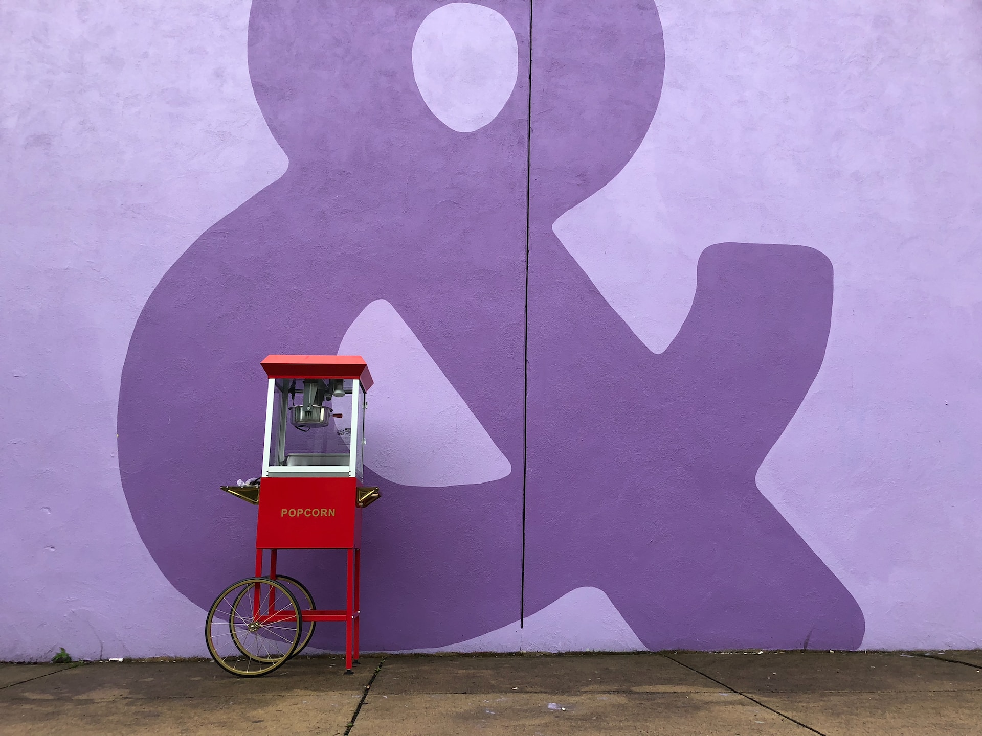 A light purple wall with an ampersand painted in dark purple