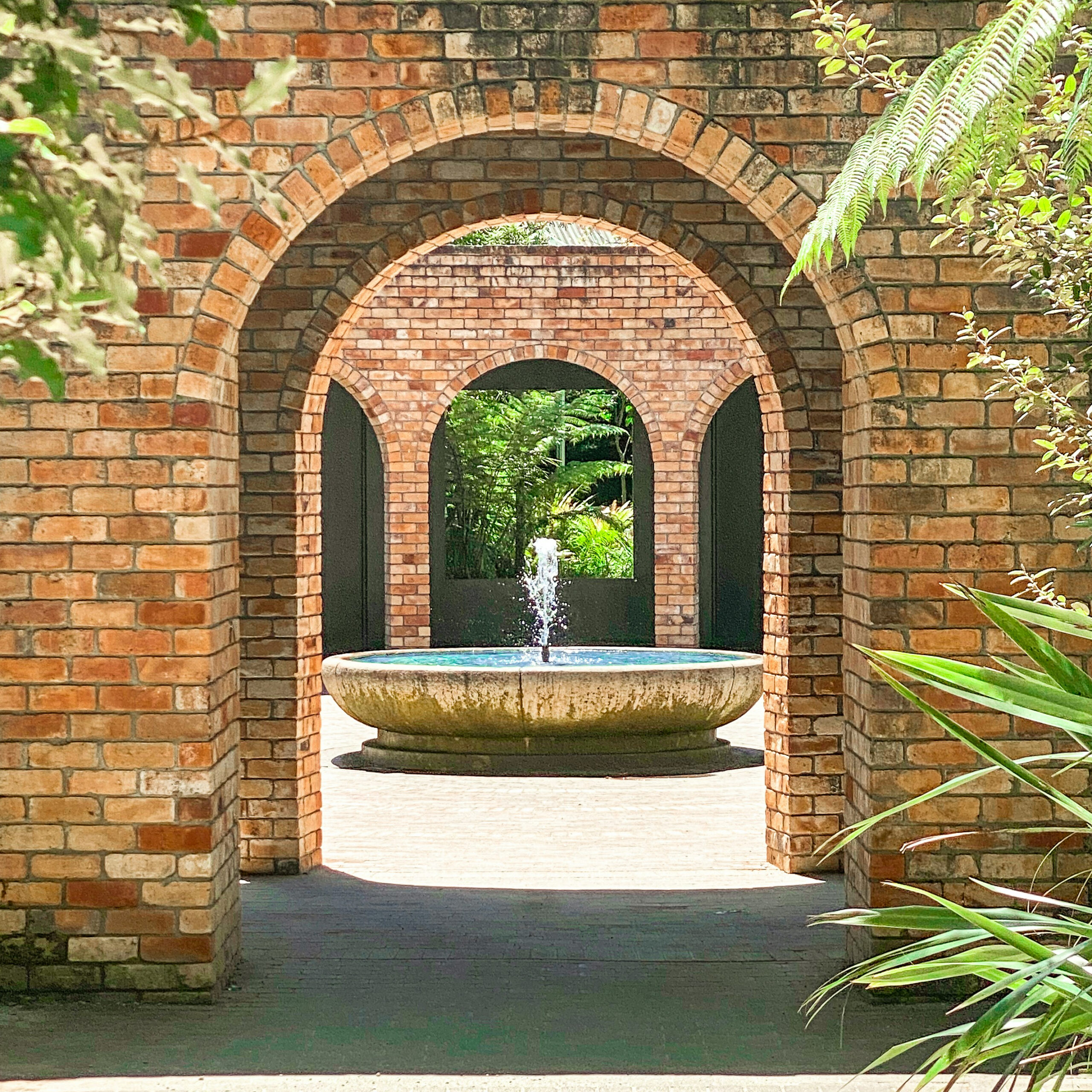 Wall with archway to garden and fountain