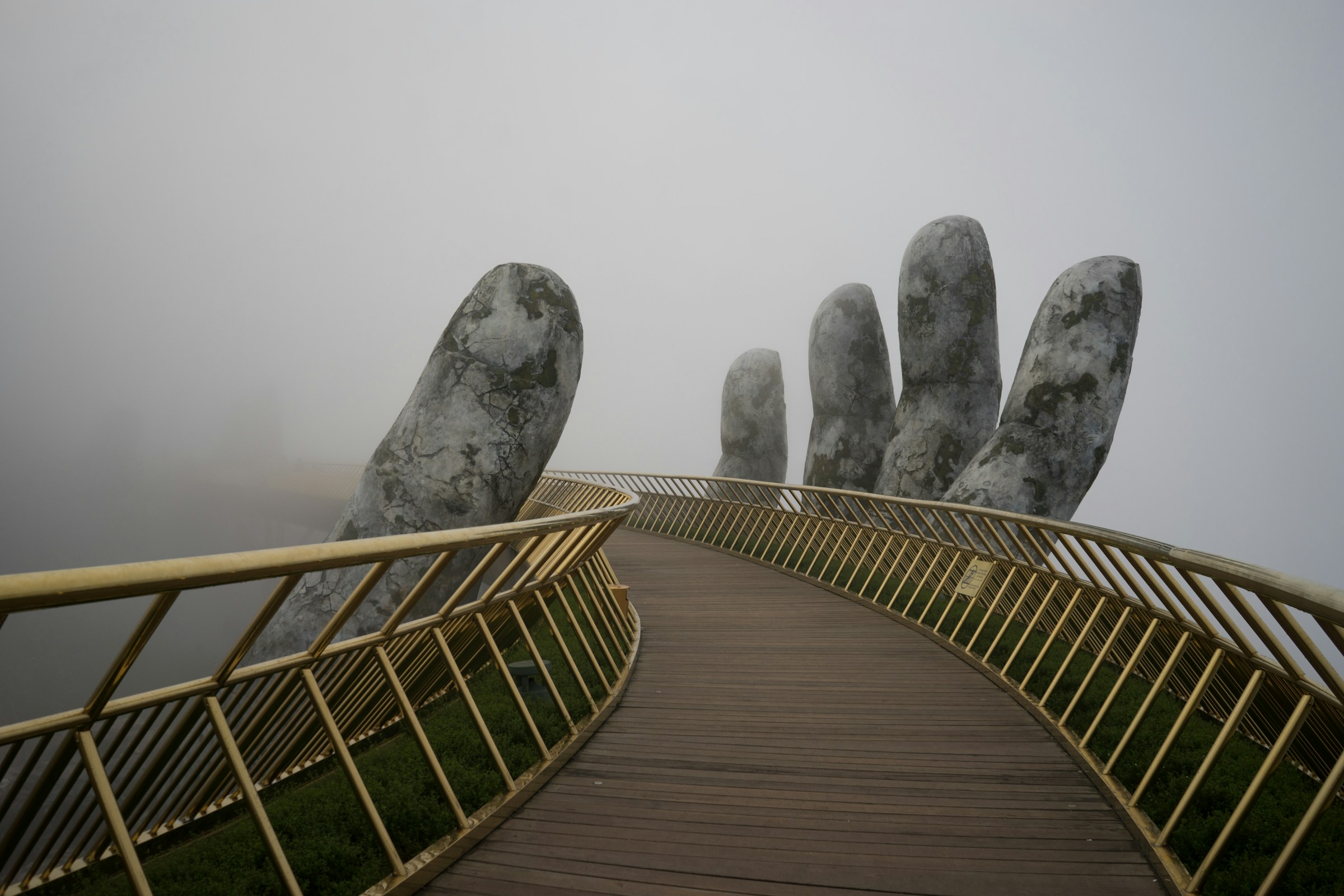 A bridge supported by a structure that is like a statue of a giant hand