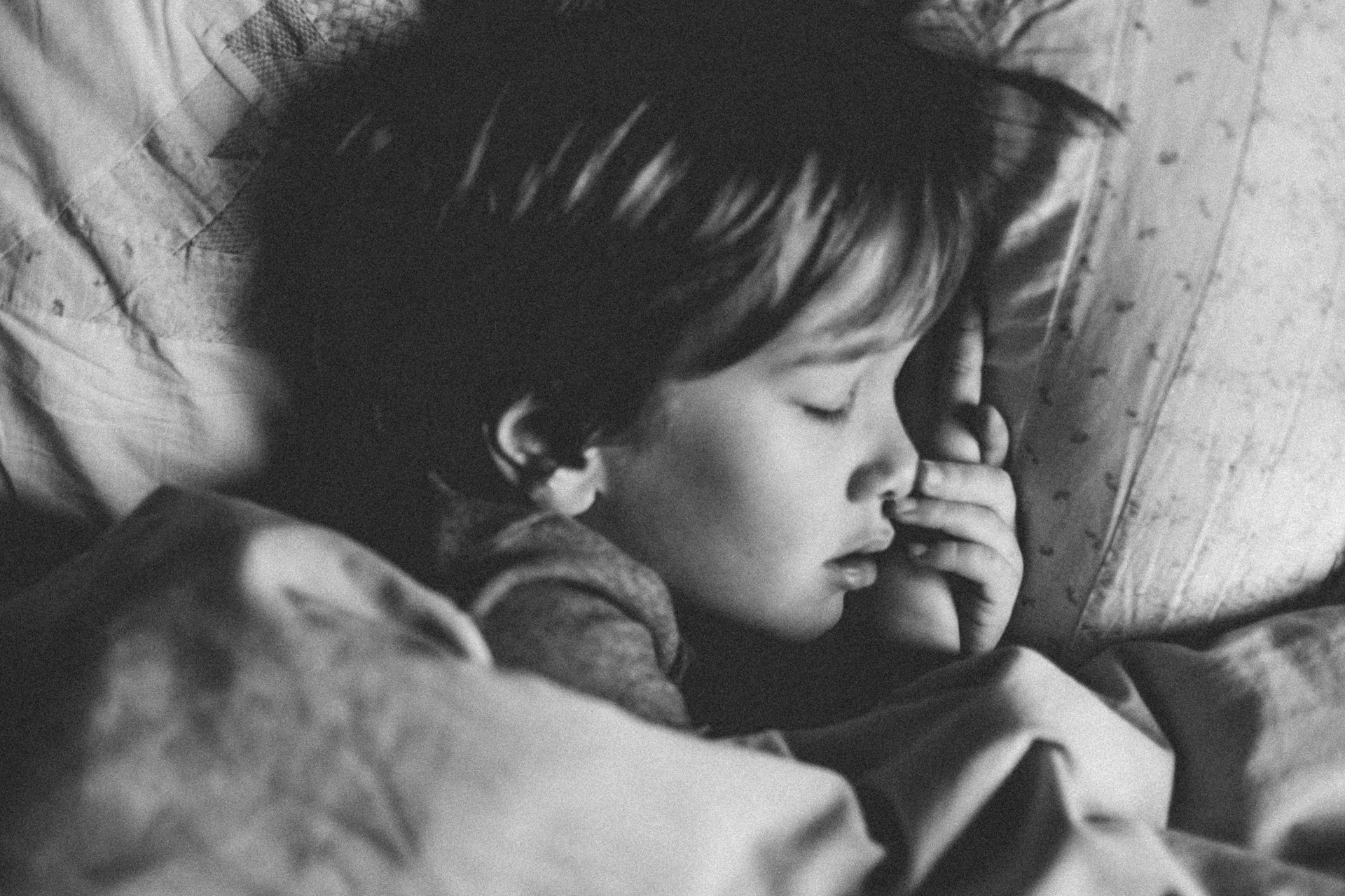Girl Sleeping Grayscale A young girl asleep in her bed, overhead shot, grayscale